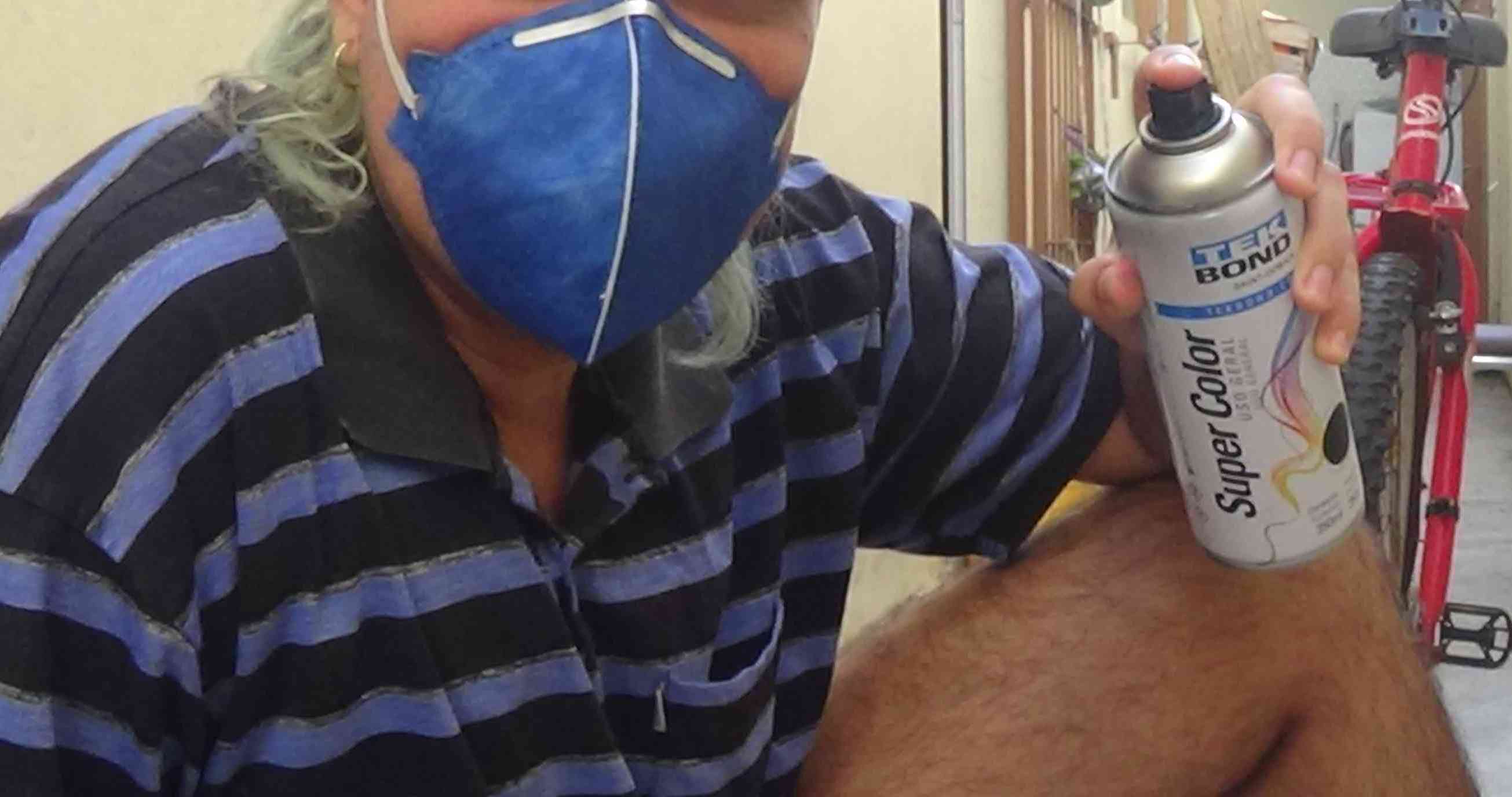 Foto de pessoa segurando um spray e usando uma máscara n-95.