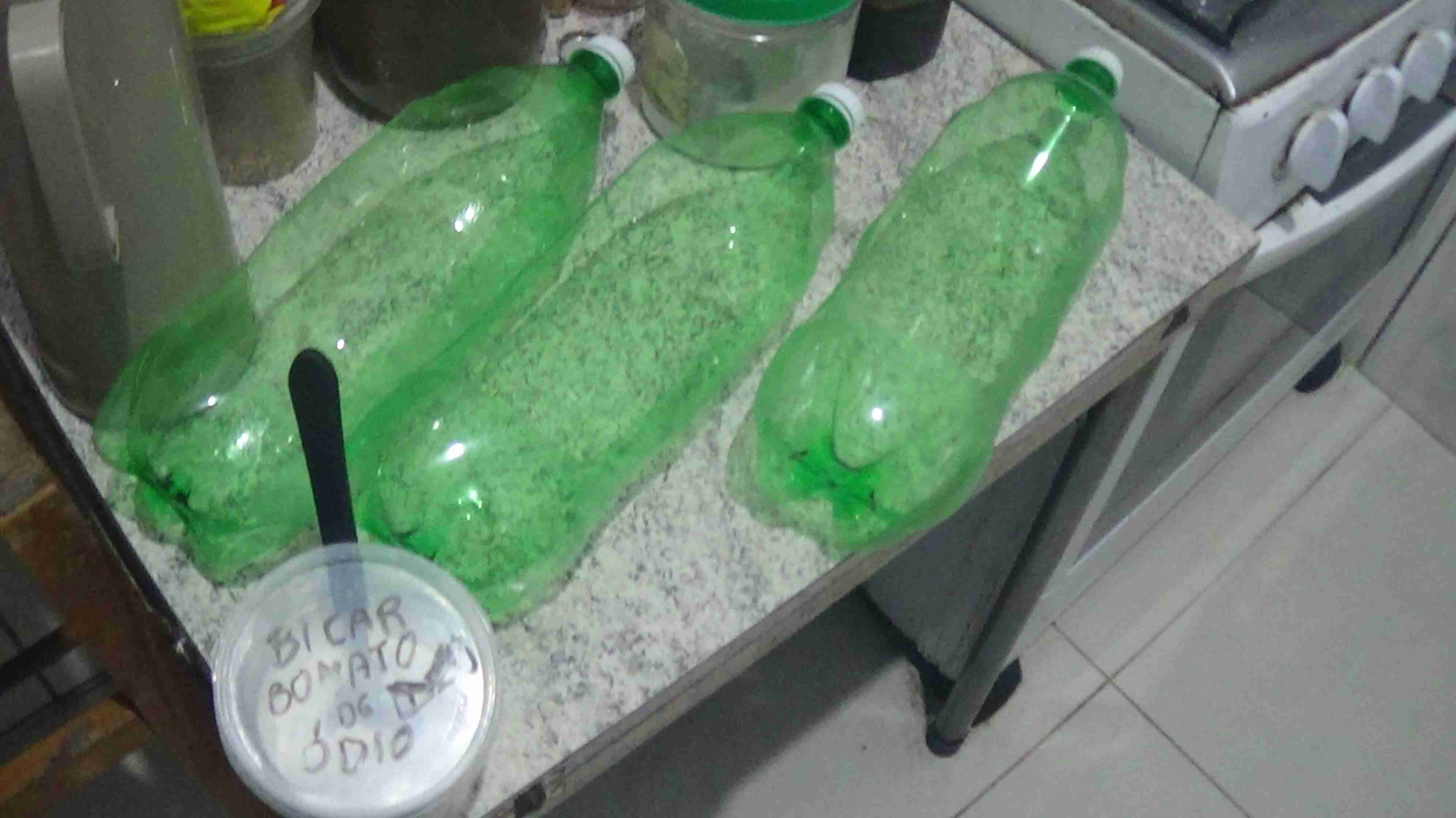 3 garrafas pets ao lado de um pote escrito: bicarbonato de ódio.
