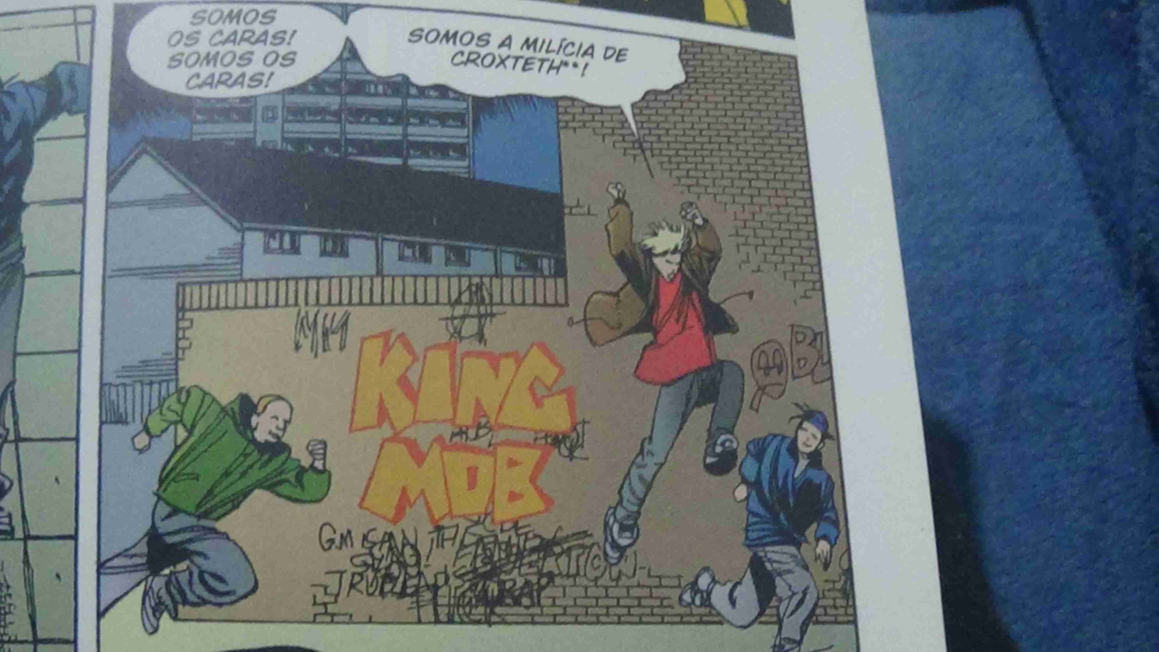 3 jovens correm, um deles diz -Somos os caras! Somos os caras! Somos a milícia de Croxteth**!. E no fundo dá para ver um grafite escrito kingmob